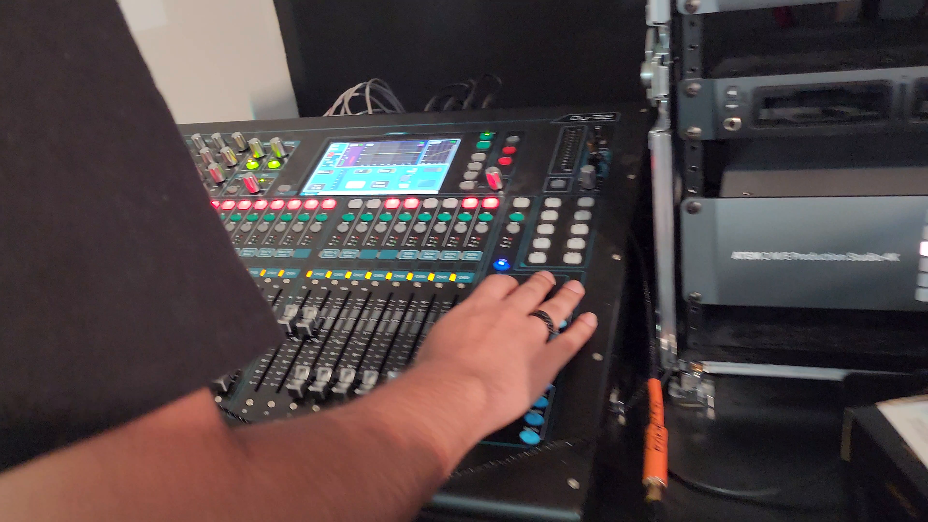 Operador de Nebula ajustando una consola digital de audio durante la producción